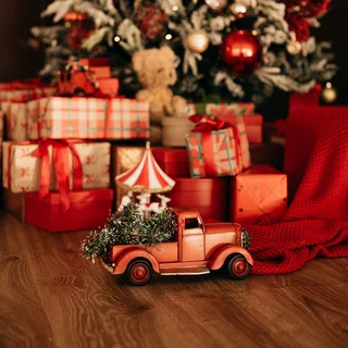 A toy truck and wrapped gifts under a tree