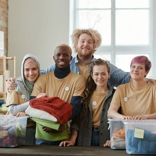 Smiling volunteers with donated clothes